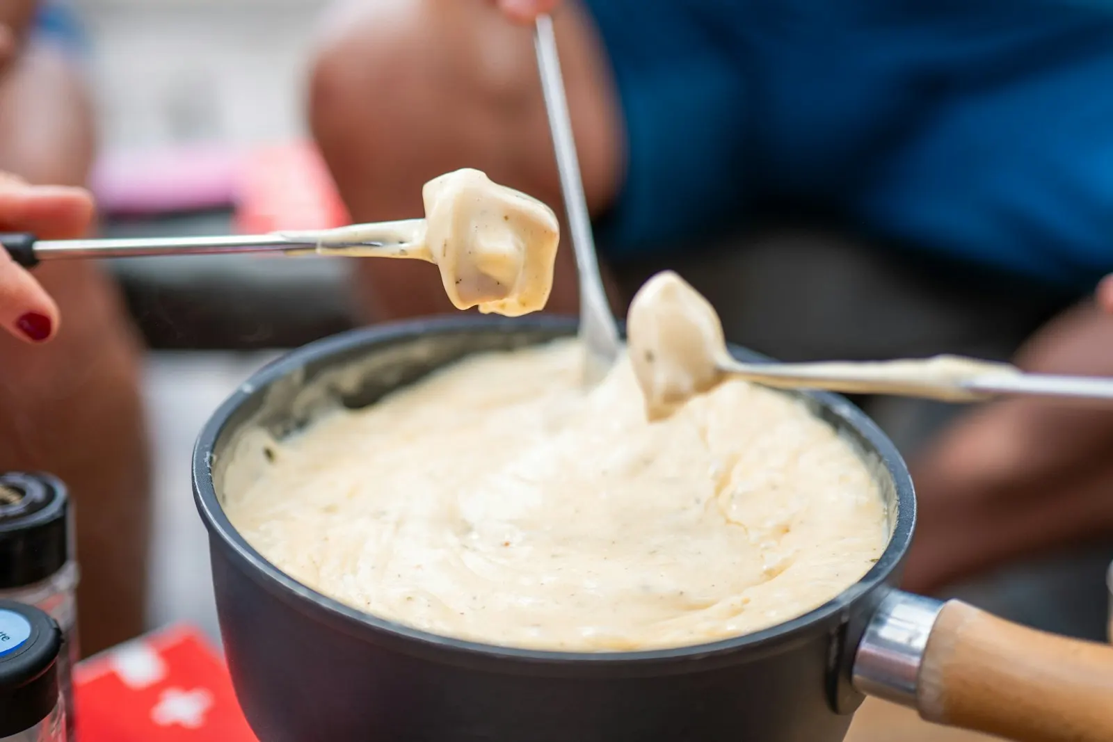 Brot wird in ein Käsefondue getaucht