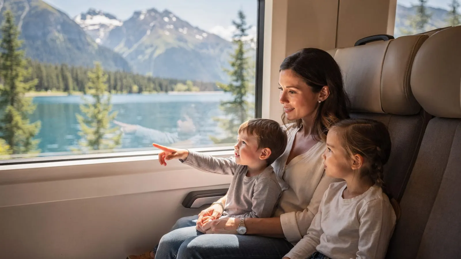 Kinder im Zug zeigen auf Berge und See